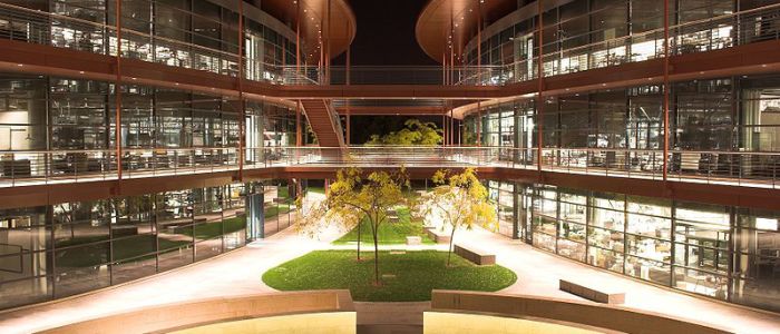 clark center lit up at night with two symmetrical three level buildings and a courtyard in between